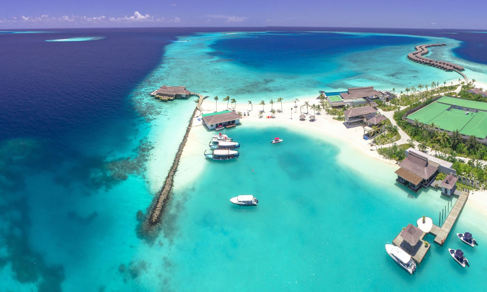 Aerial view of a Maldives island resort ringed by turquoise sea