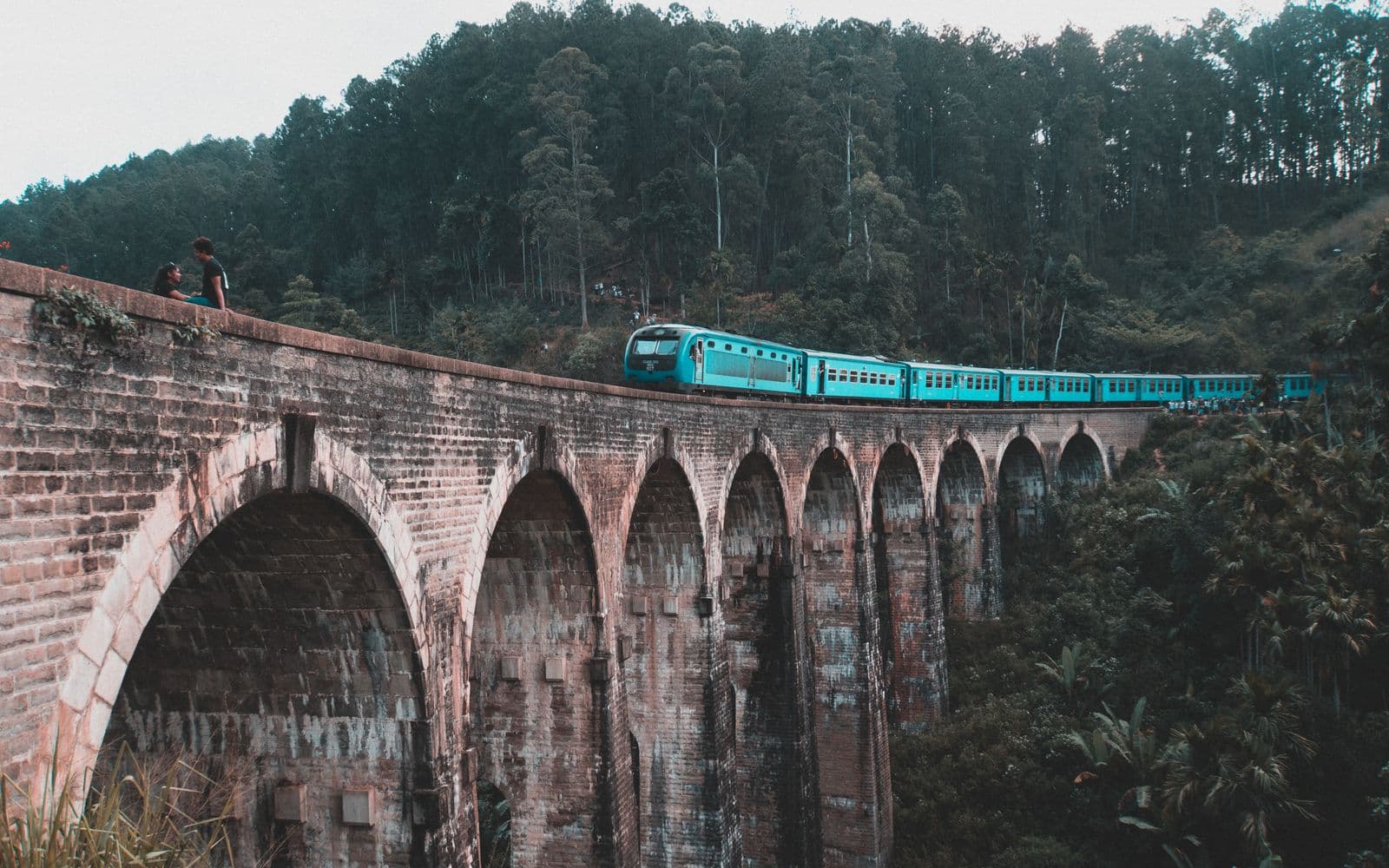 Blue train crossing the Nine Arch Bridge amid Sri Lankan forest, Ella