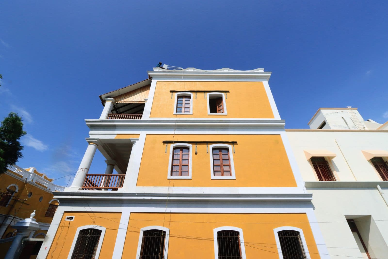 A yellow colonial building with tall columns in the French Quarter of Puducherry