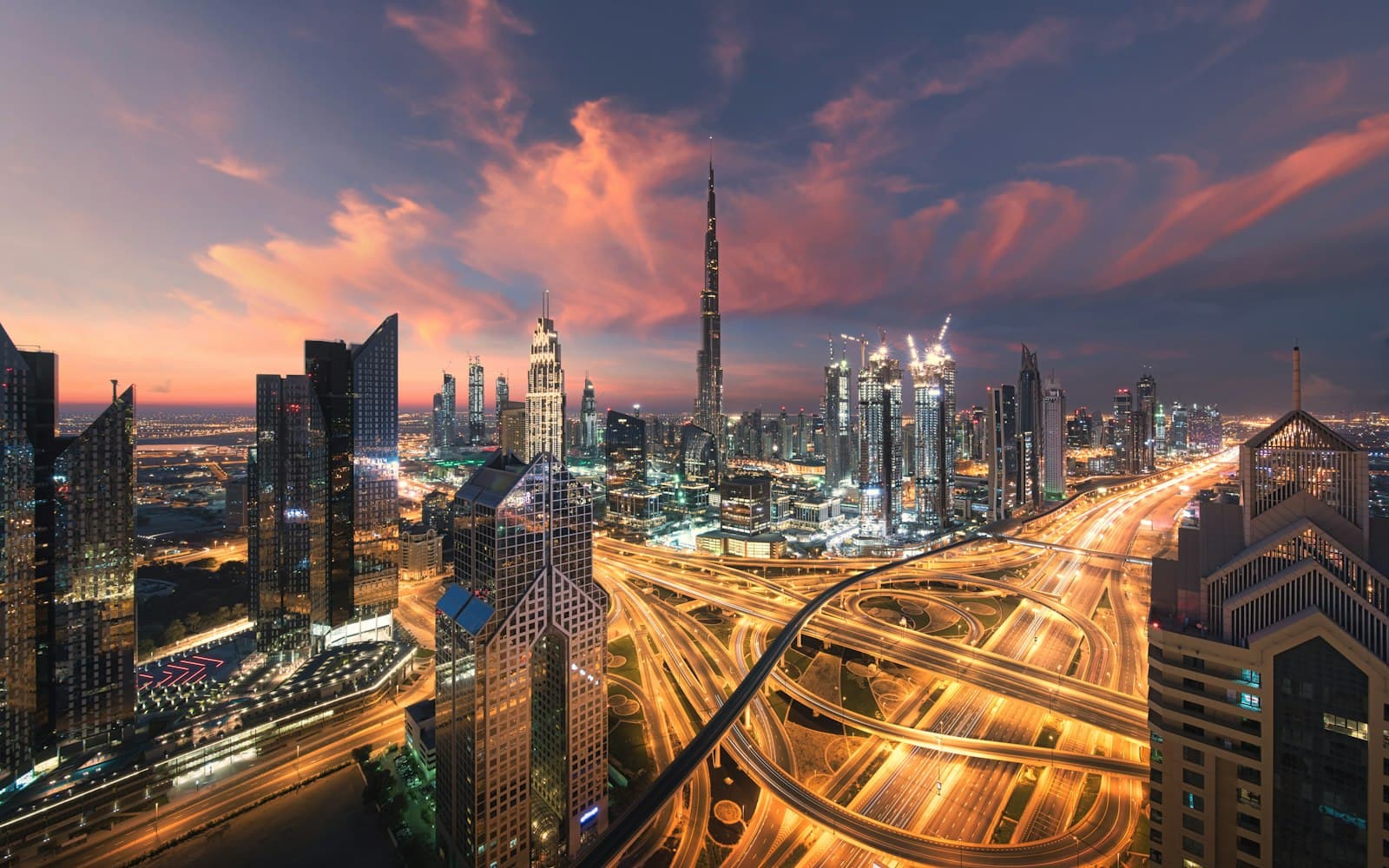 Downtown Dubai and Sheikh Zayed Road lit up at dusk, seen from a tower