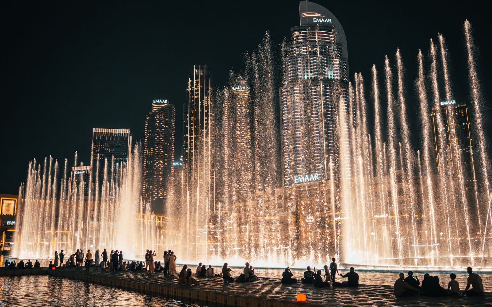 The Dubai Fountain show at night in front of the Downtown towers