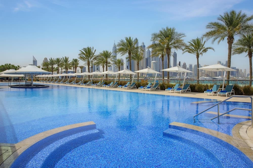 Long pool lined with palm trees at Hilton Dubai Palm Jumeirah