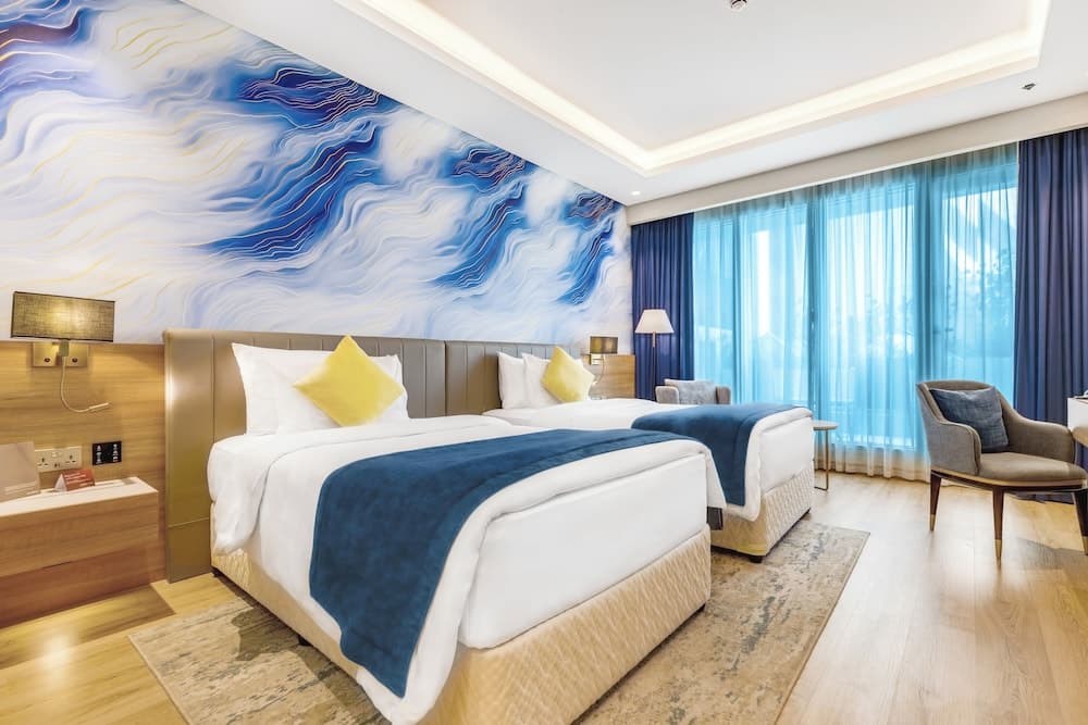 Guest room at Movenpick Grand Al Bustan Dubai with a king bed