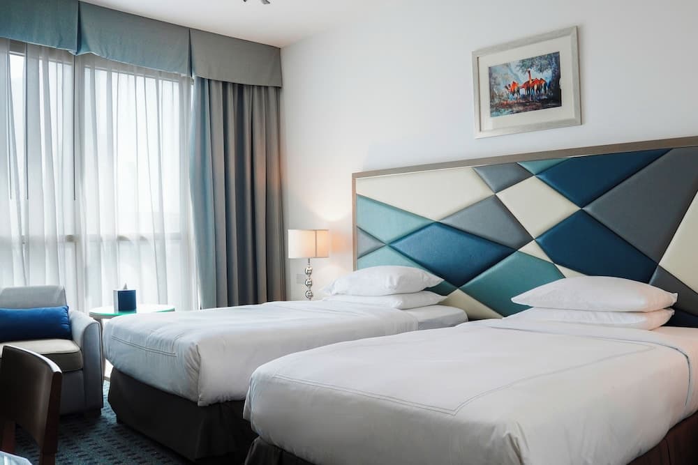 Guest room with twin beds at Swissotel Al Murooj Dubai